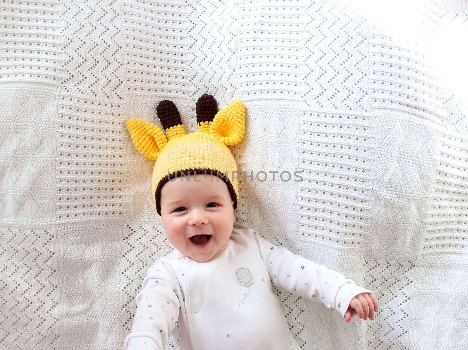 little boy lying on soft white blanket