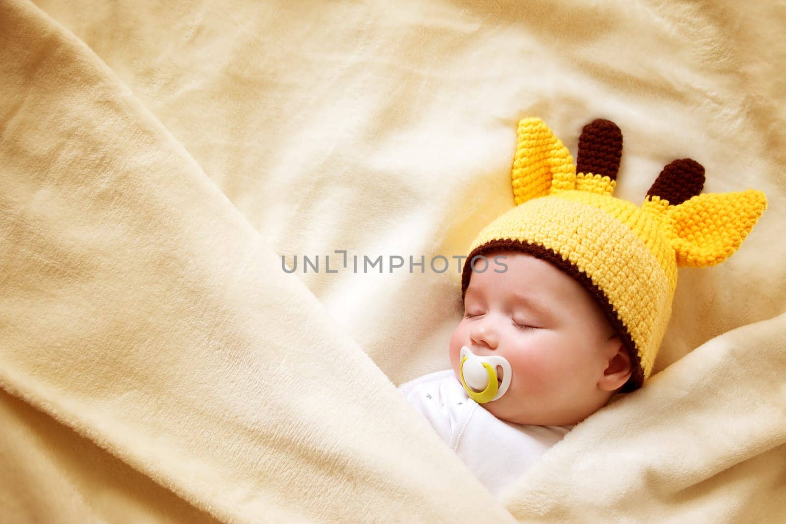 little boy sleeping on soft cream blanket