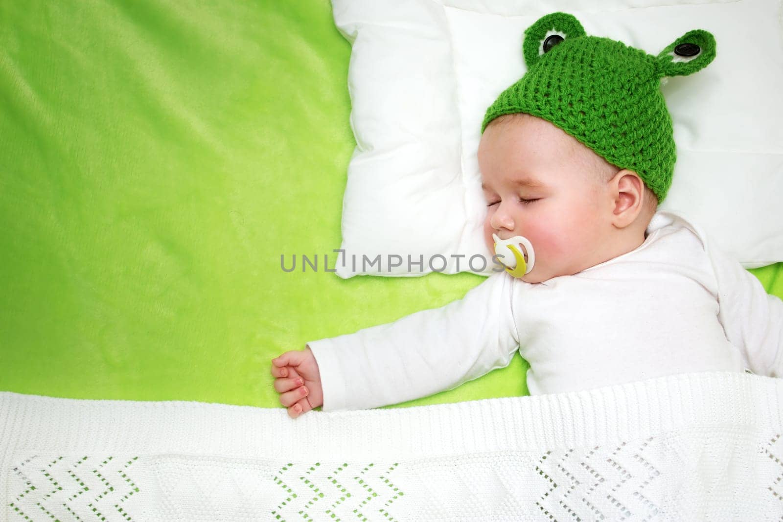little boy lying on soft green blanket