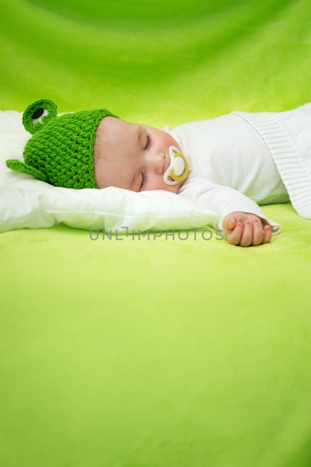 little boy lying on soft green blanket