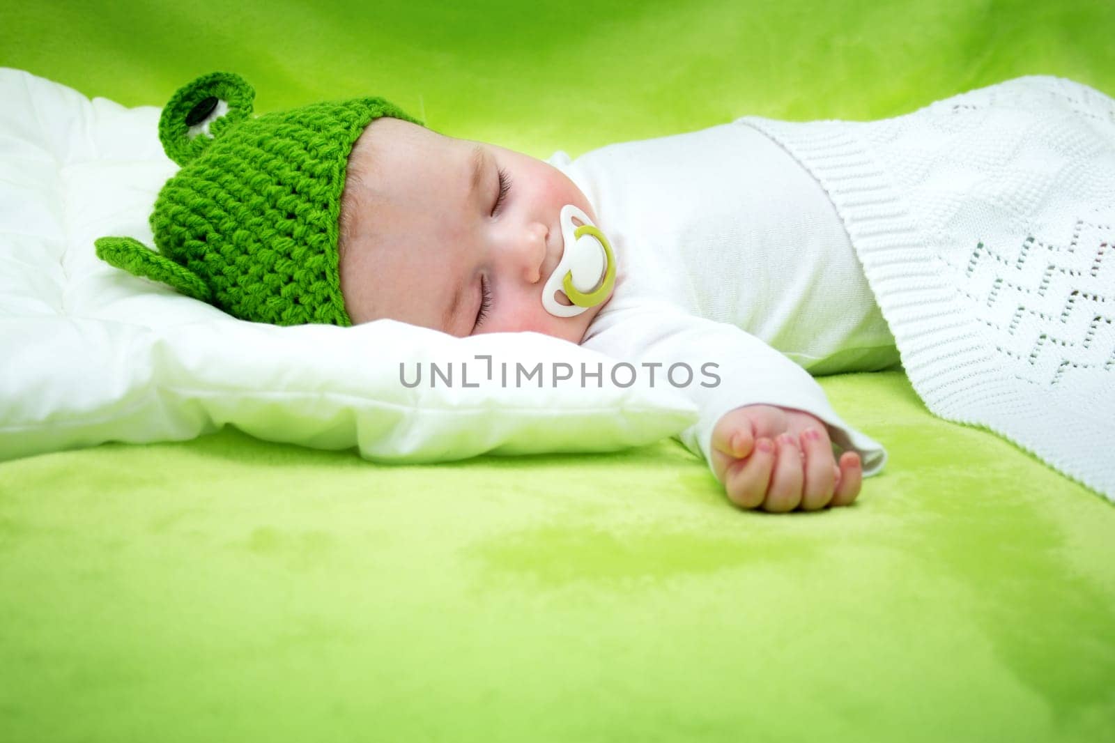 little boy lying on soft green blanket