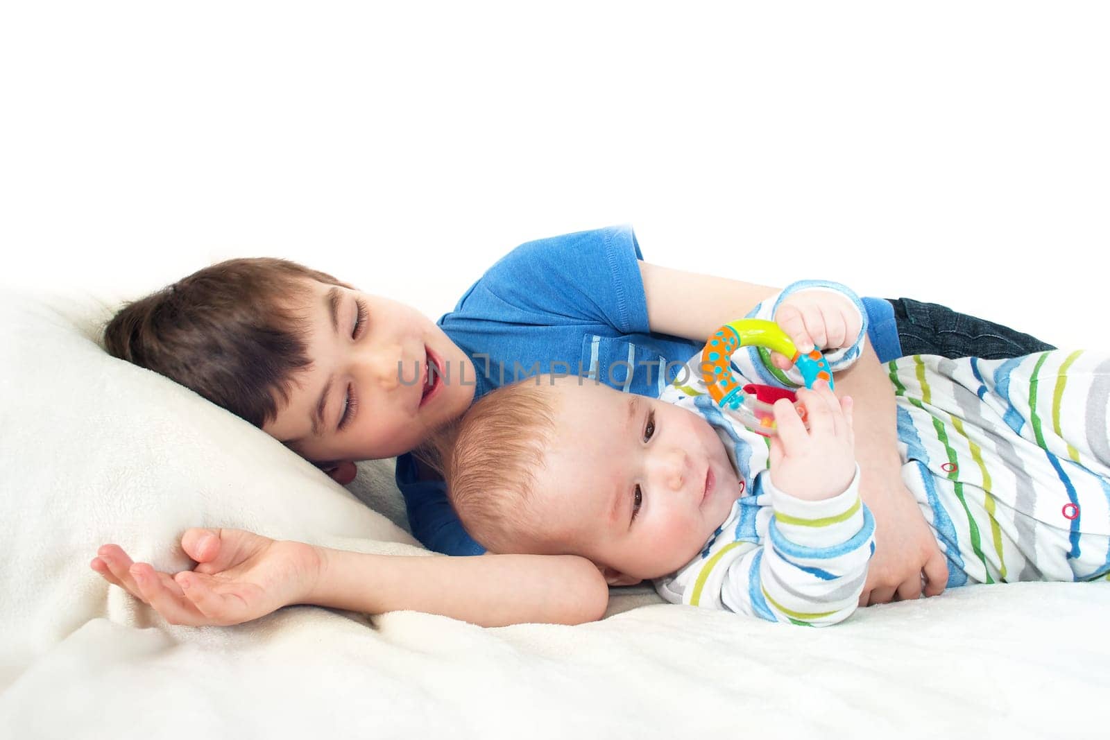 two brothers lying on soft white blanket