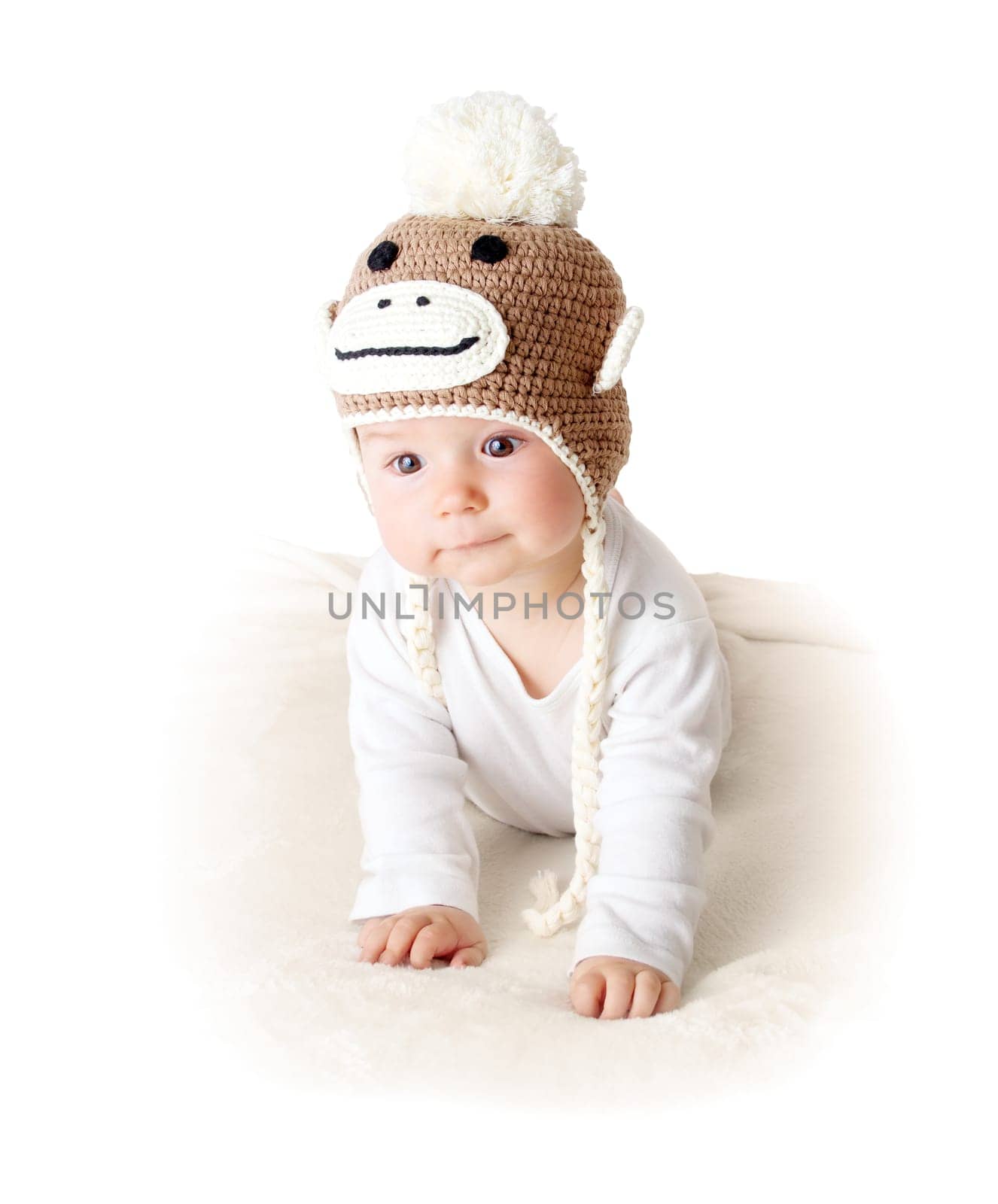 little baby in knitted montey hat on brown blanket