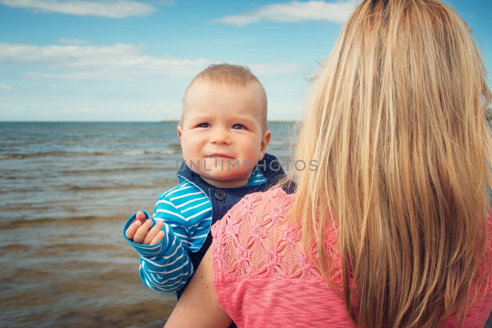young woman and baby at the beach near sea