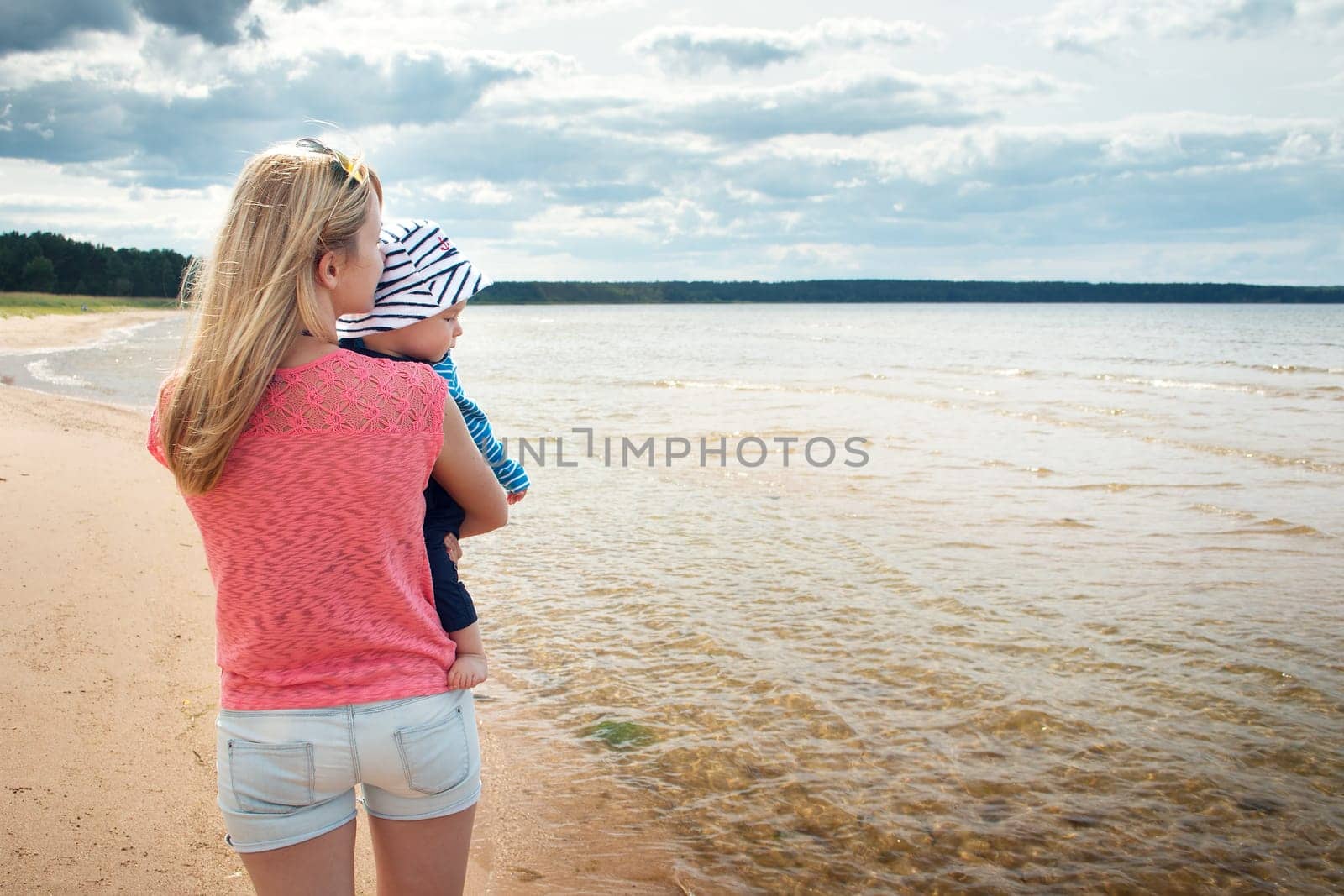 young woman and baby at the beach near sea