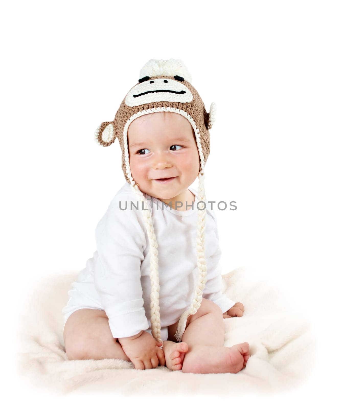 little baby in knitted monkey hat on brown blanket