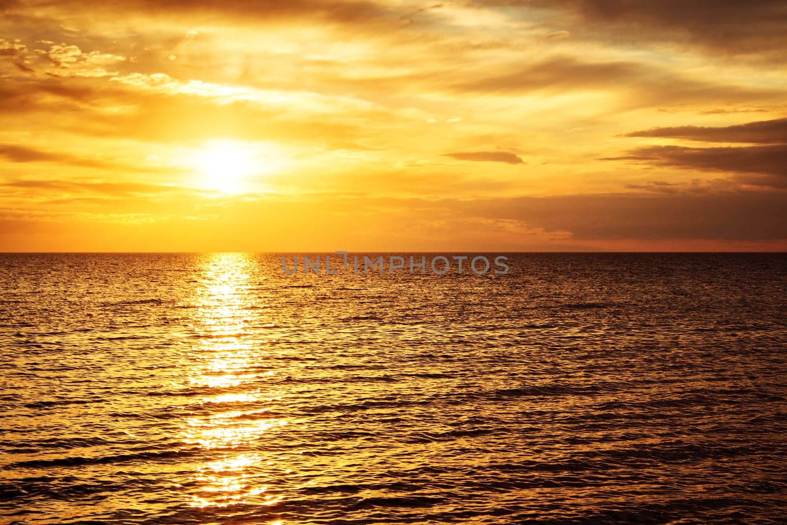 sunset at the sea with beautiful orange water and clouds