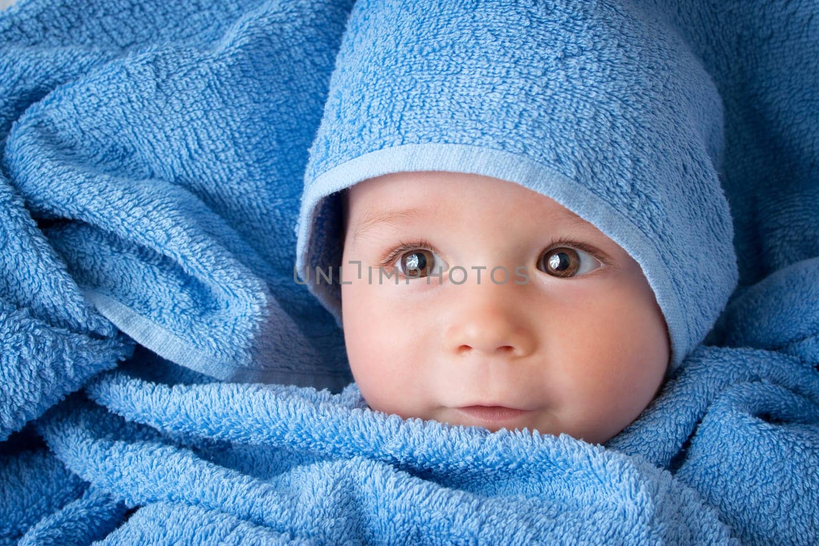 Cute eight month old baby wrapped in a towel