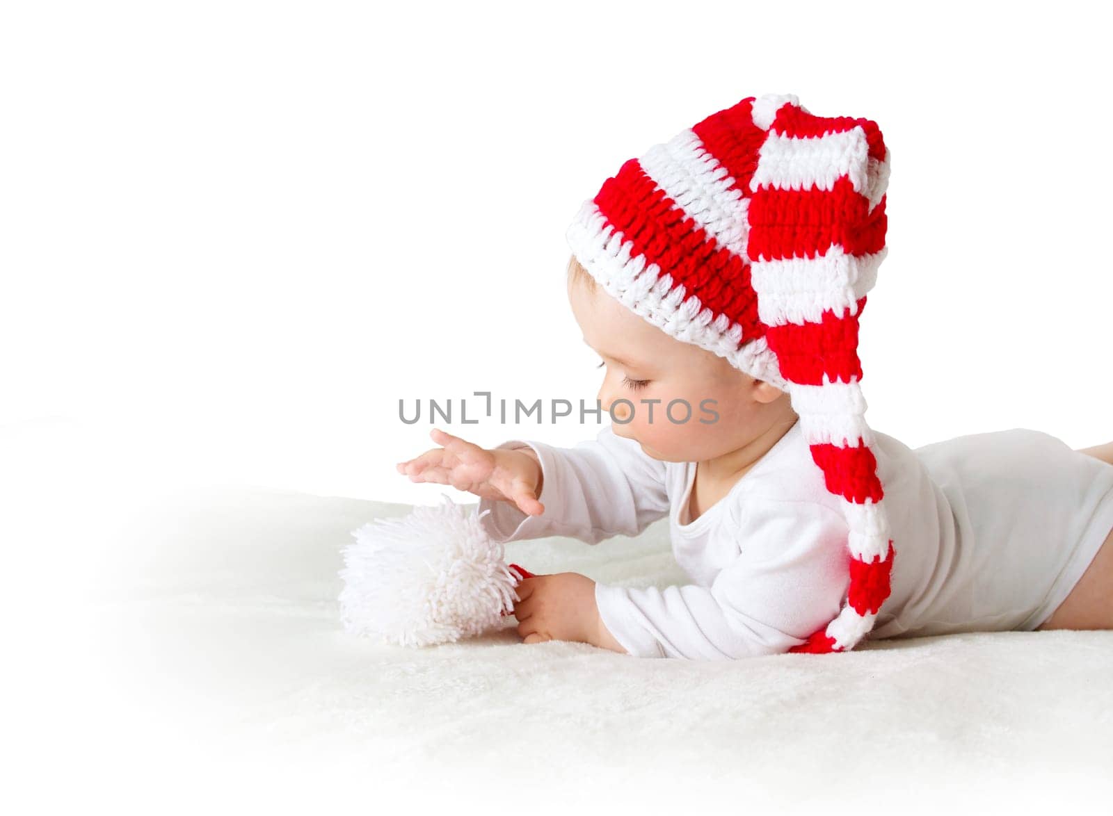 little baby in knitted red whitey hat on red blanket