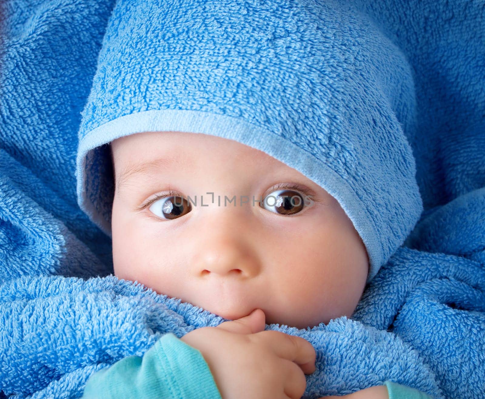 Cute eight month old baby wrapped in a towel