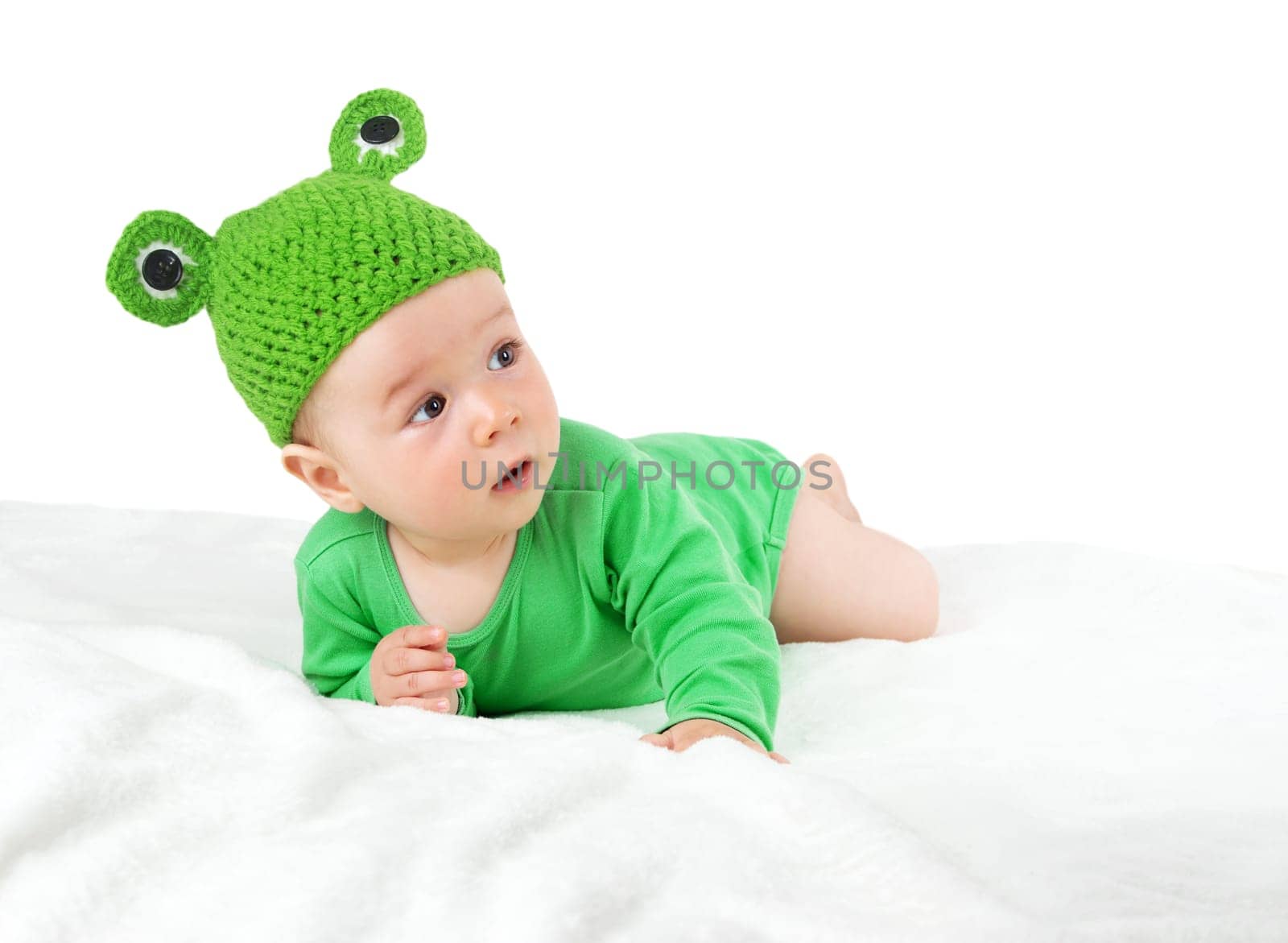 little baby in knitted frog hat on soft blanket