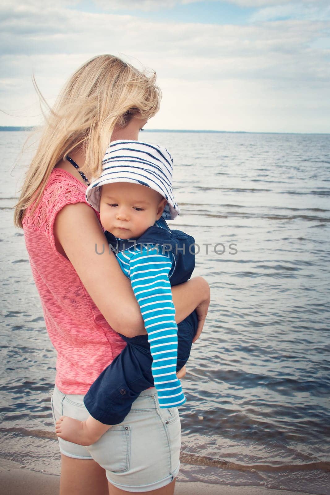 young woman and baby at the beach near sea