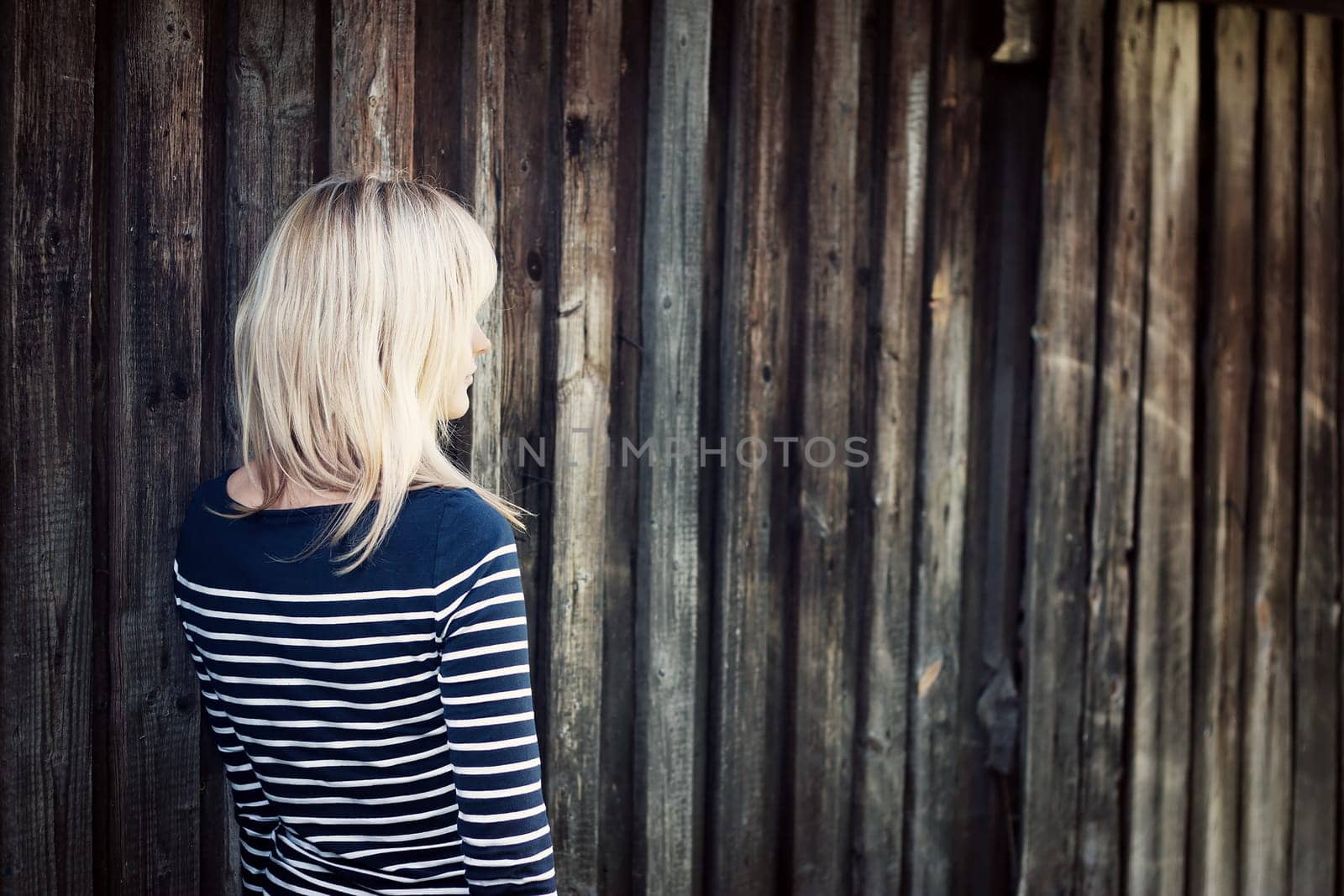 Young woman portrait infront of rustic wooden wall