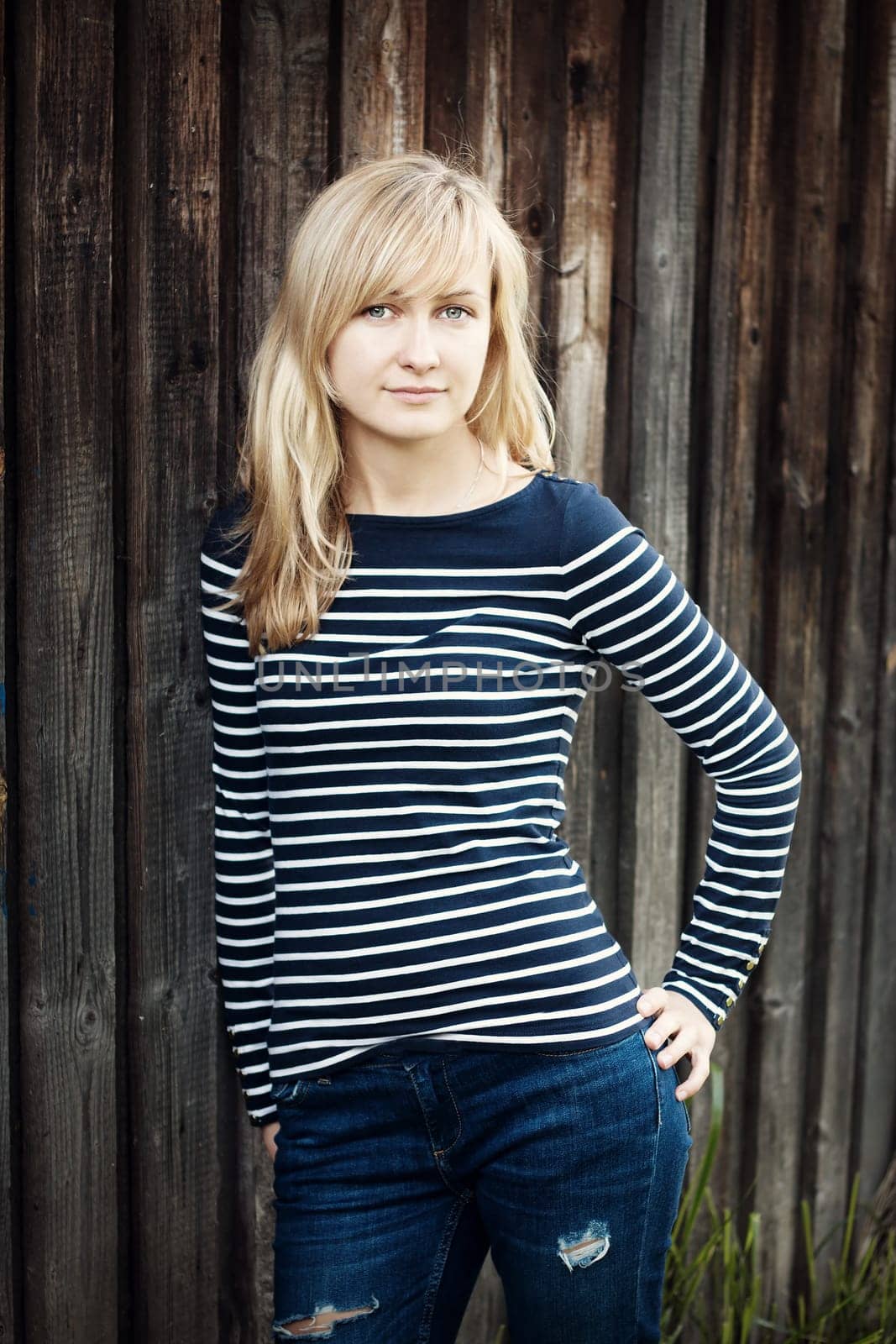 Young woman portrait infront of rustic wooden wall