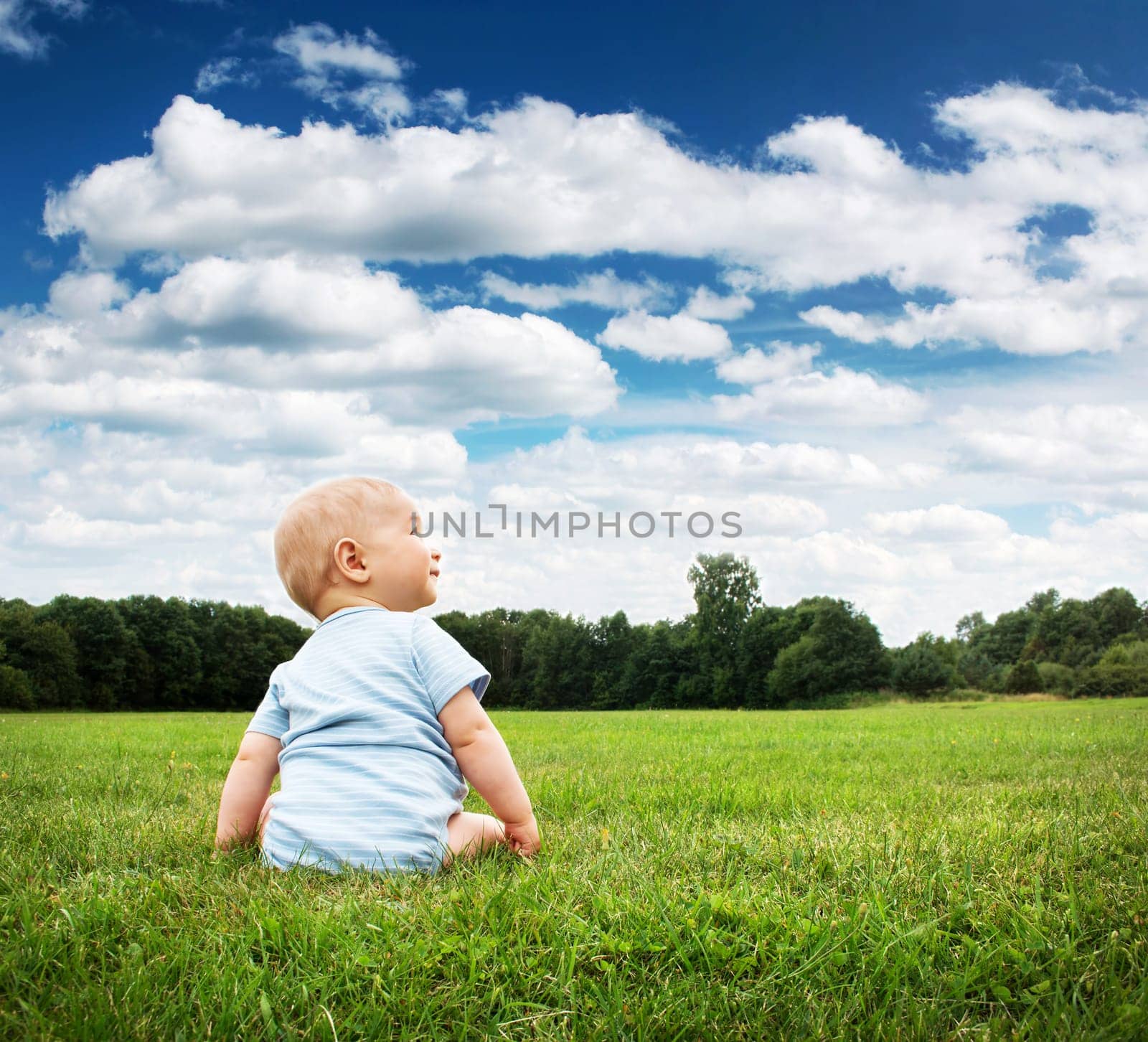 Little baby boy sitting on the grass