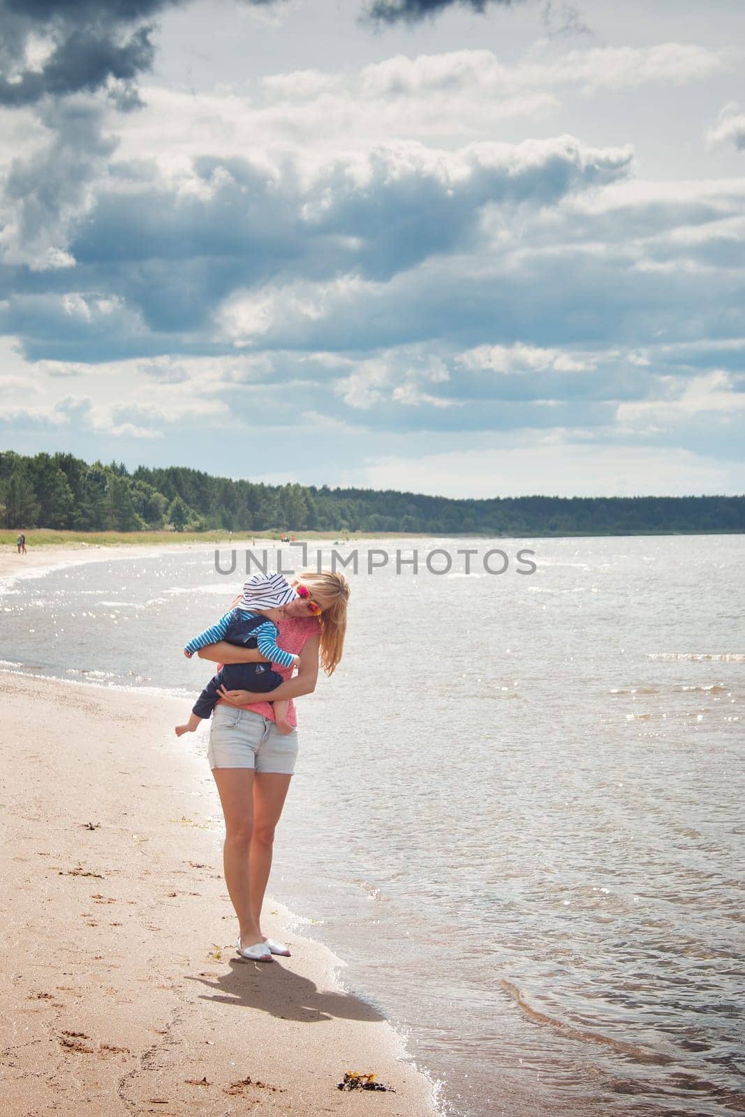 young woman and baby at the beach near sea