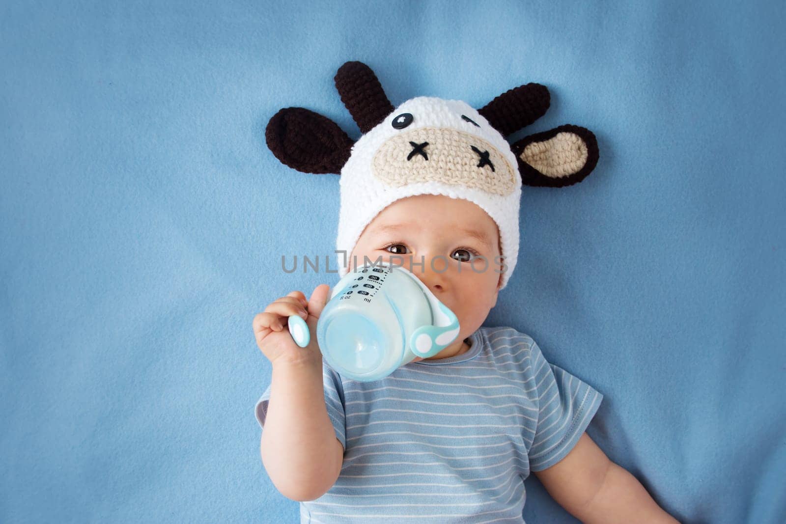 cute baby in a cow hat drinking milk