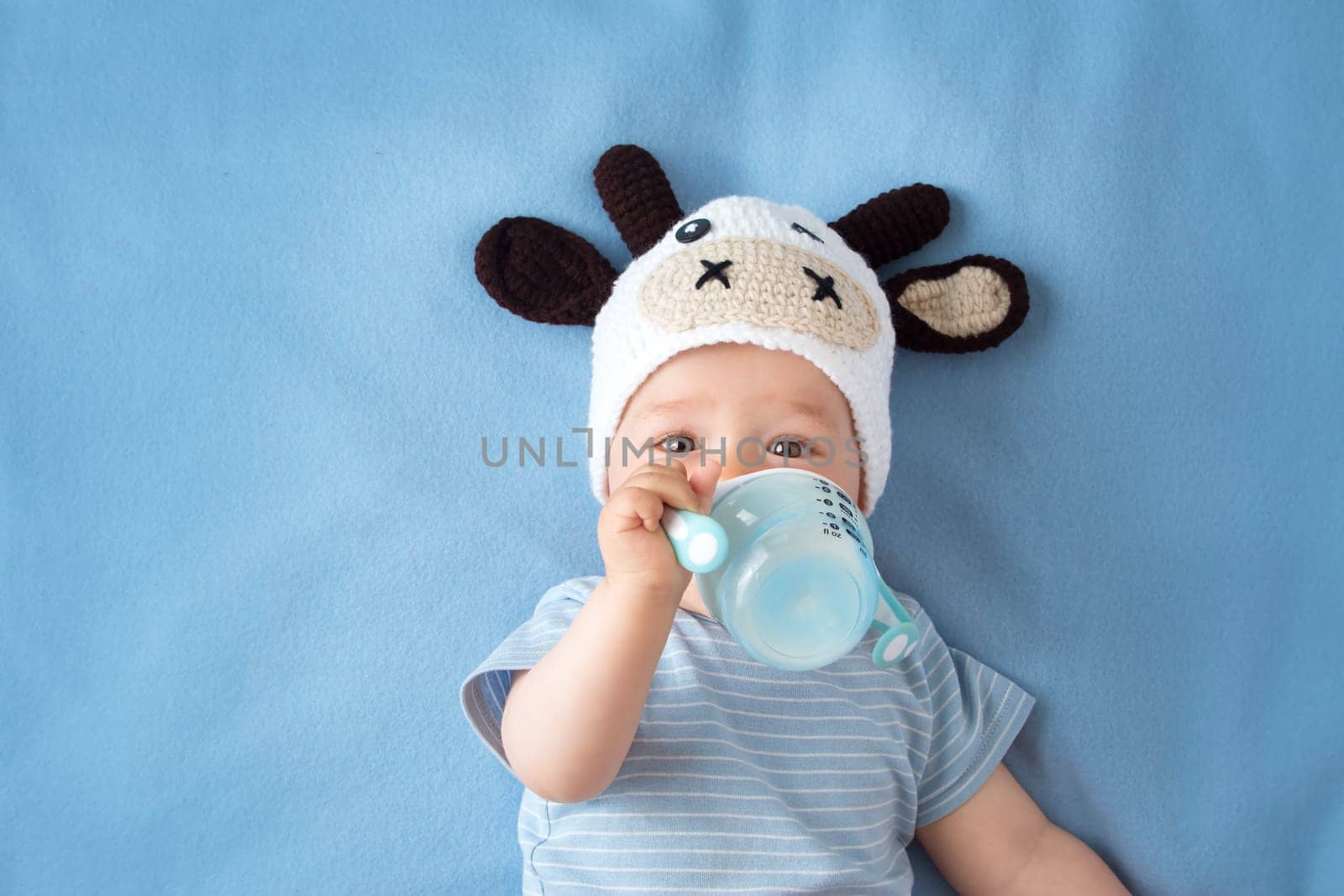 cute baby in a cow hat drinking milk