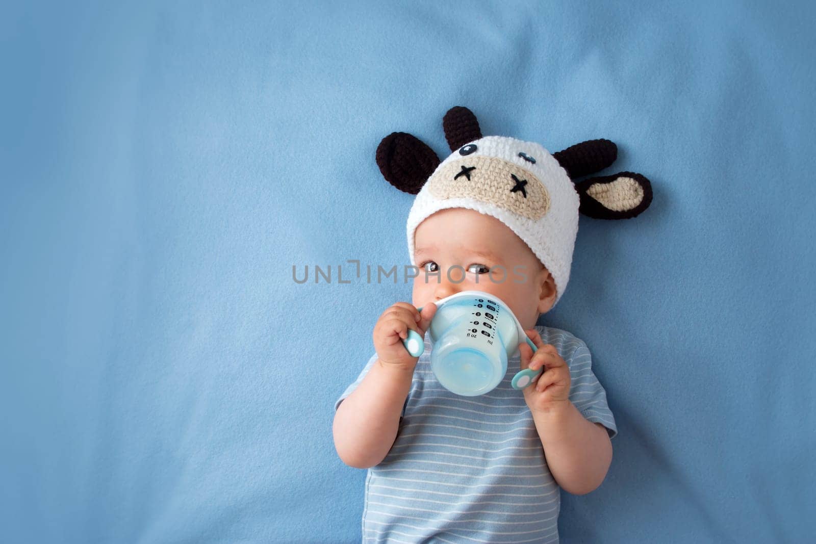 cute baby in a cow hat drinking milk