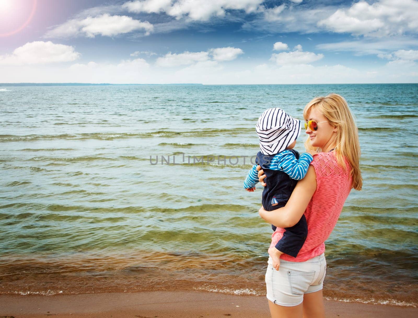 young woman and baby at the beach near sea