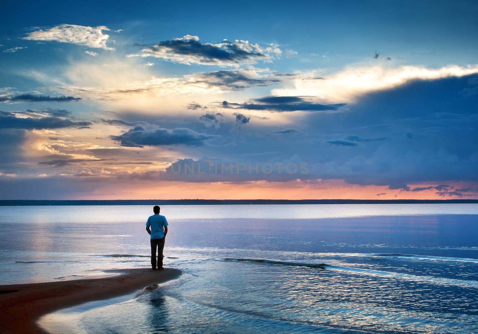 Alone man stamding at the sea in twilight