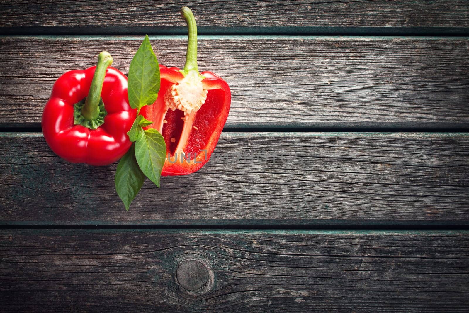 Fresh sweet red pepper on old wooden background
