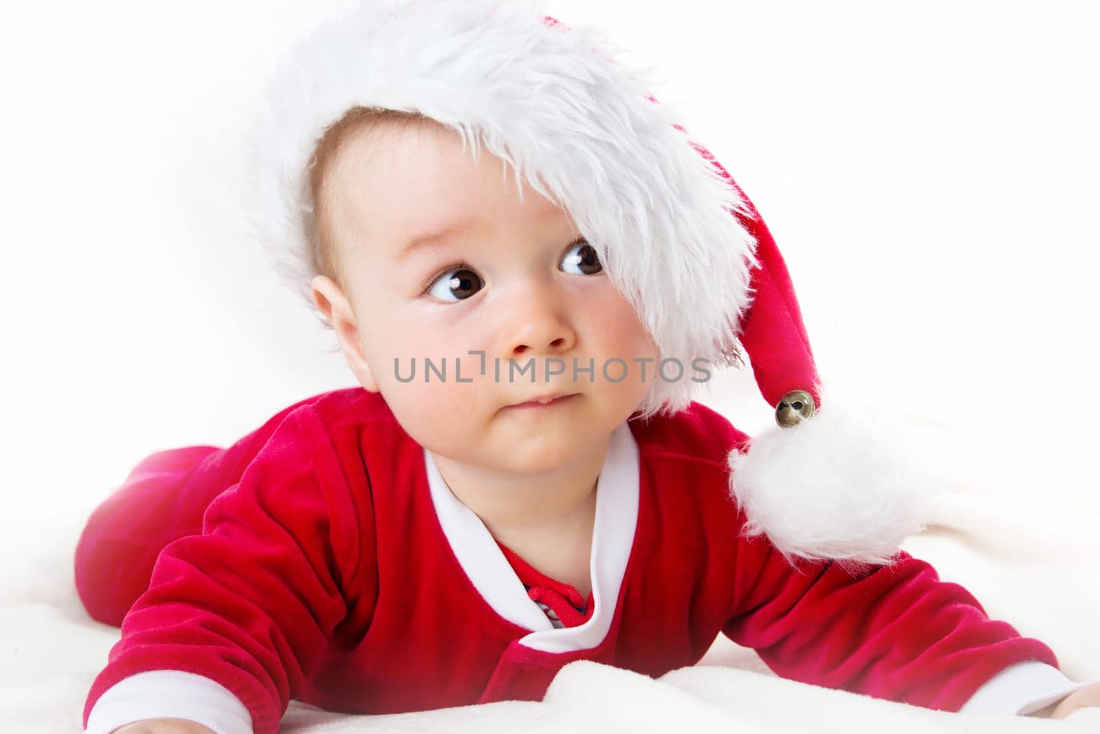 eight month old baby on white background in santa costume