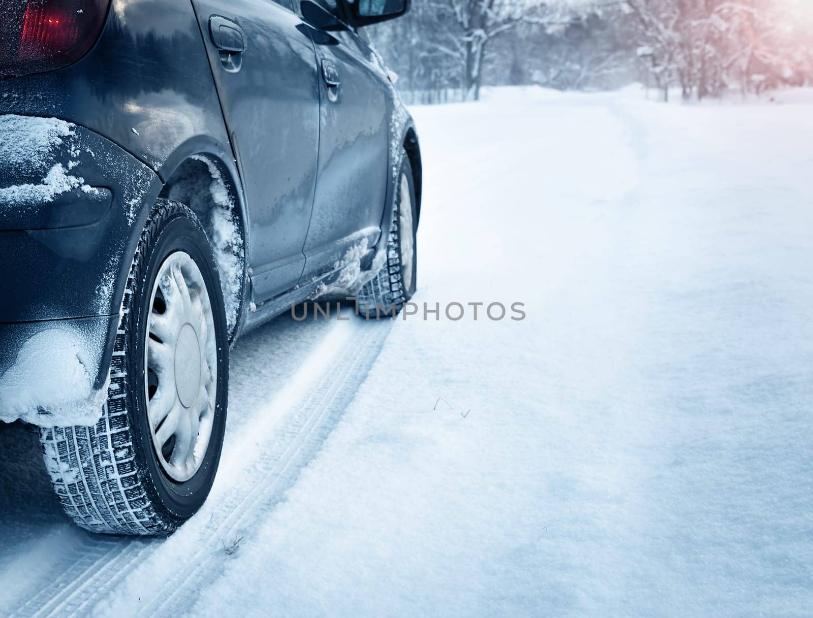 Closeup of car tires in winter on the road covered with snow