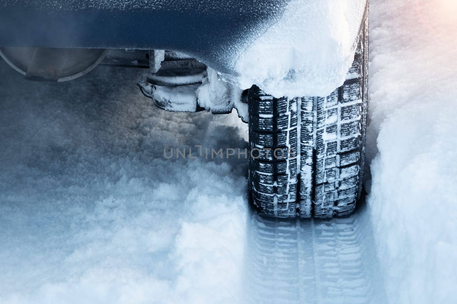 Closeup of car tires in winter on the road covered with snow