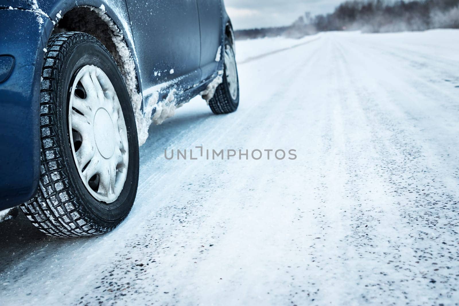 Closeup of car tires in winter on the road covered with snow