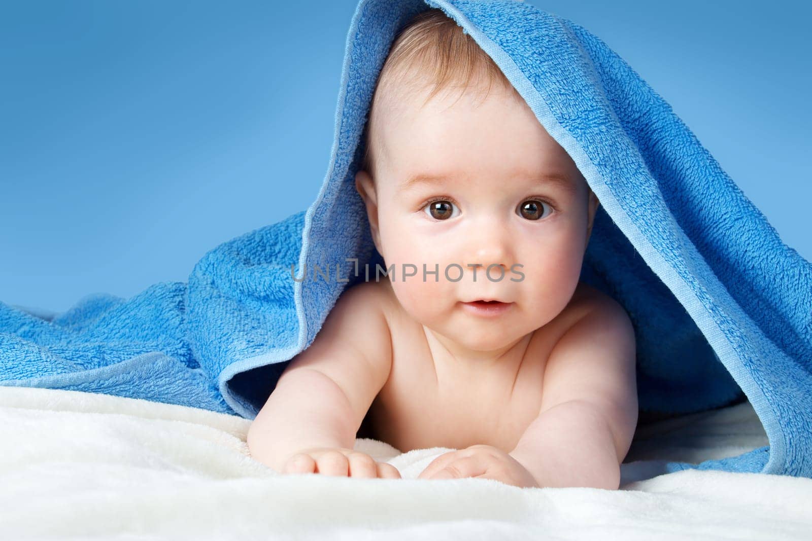 Cute eight month old baby wrapped in a towel