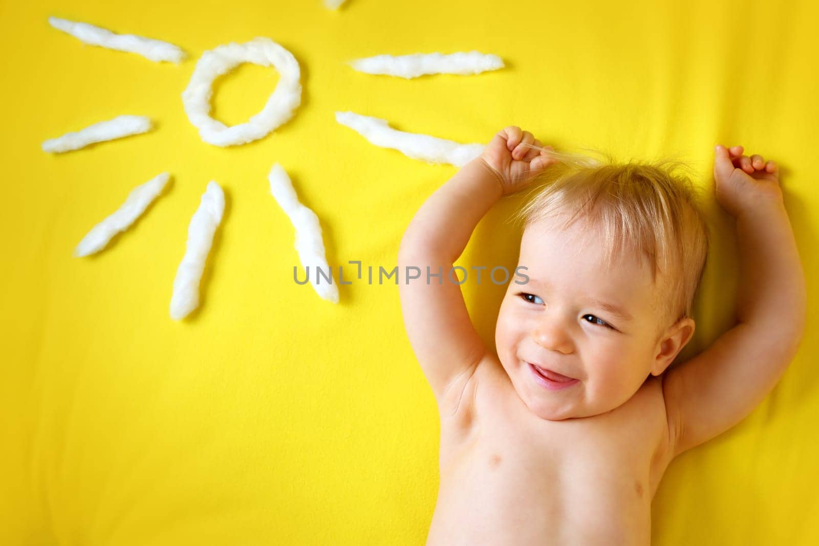 little boy with sunglasses and sun shape on yellow blanket