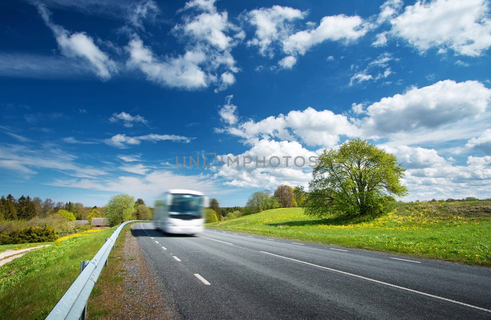 Bus on asphalt road in beautiful spring day at countryside