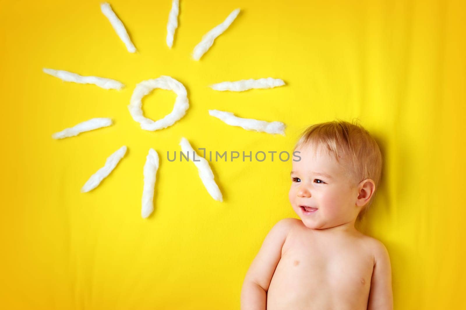 little one year old boy and sun shape on yellow blanket