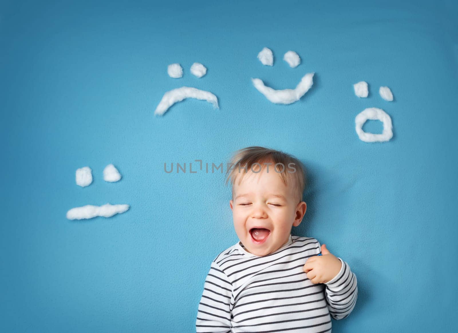 happy little boy on blue blanket background