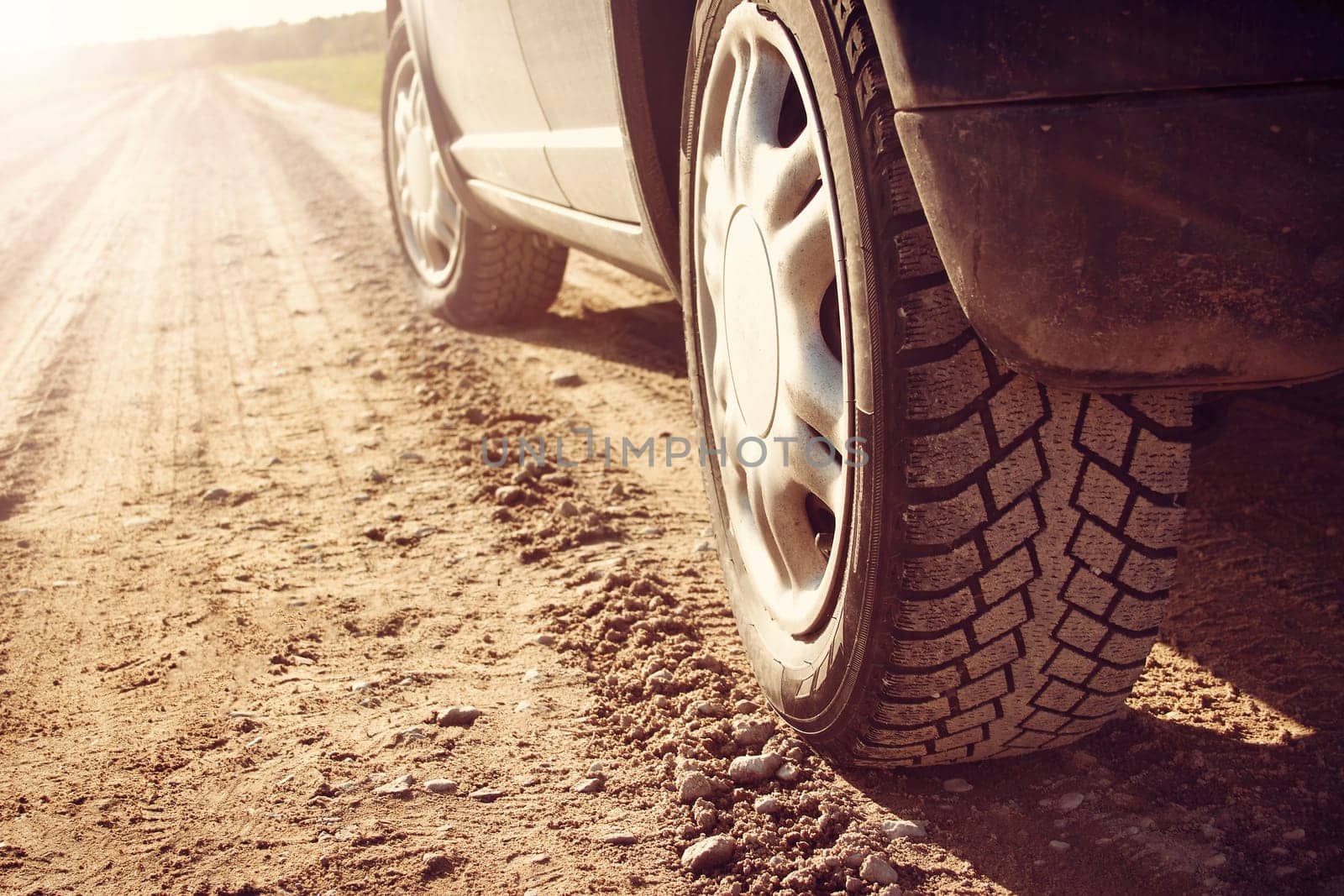 car tire on gravel road in evening light