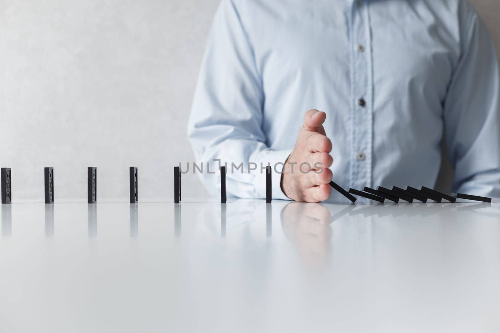 Man prevent of domino falling. Social distancing and saving from spreading virus, concept.