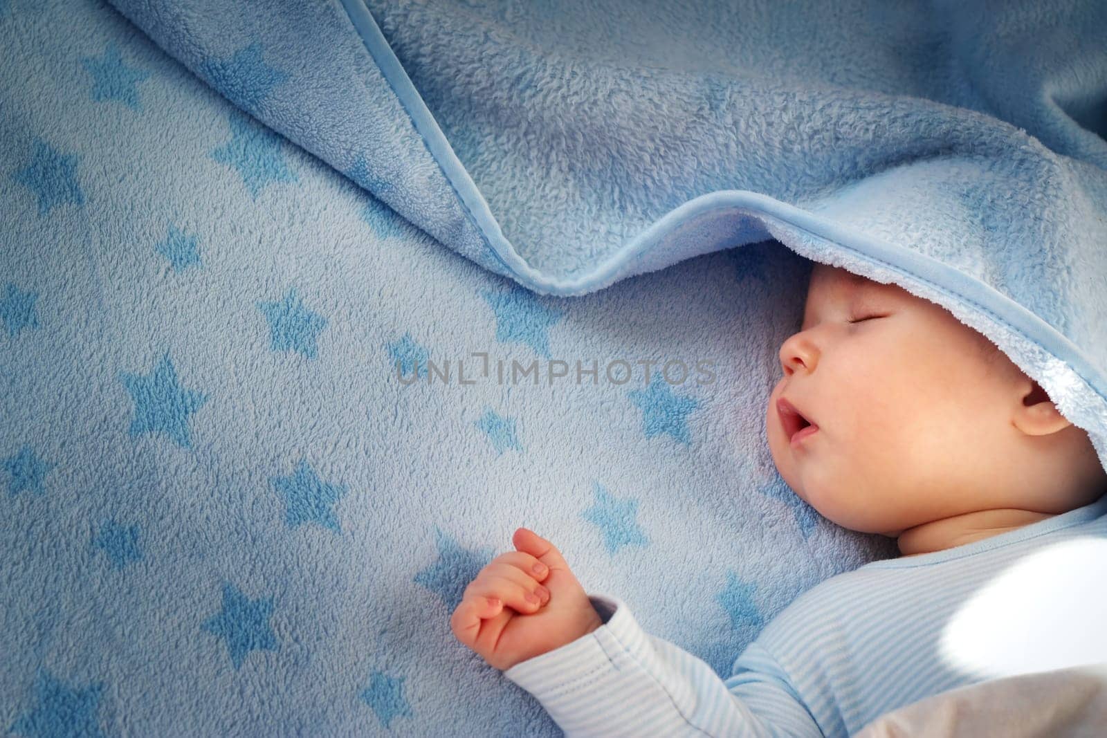 3 month old baby sleeping on blue blanket with stars