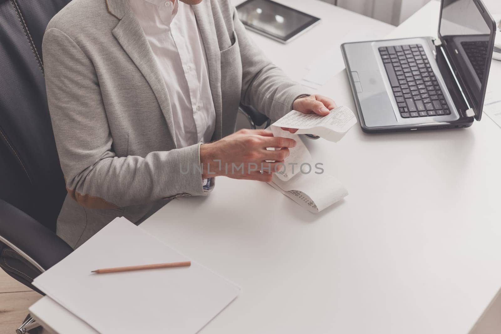 Man watches a check while sitting at a table