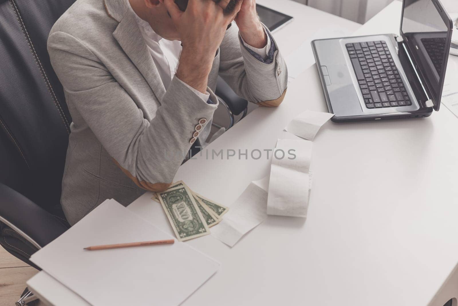 Young man frustrated at his house by debt.