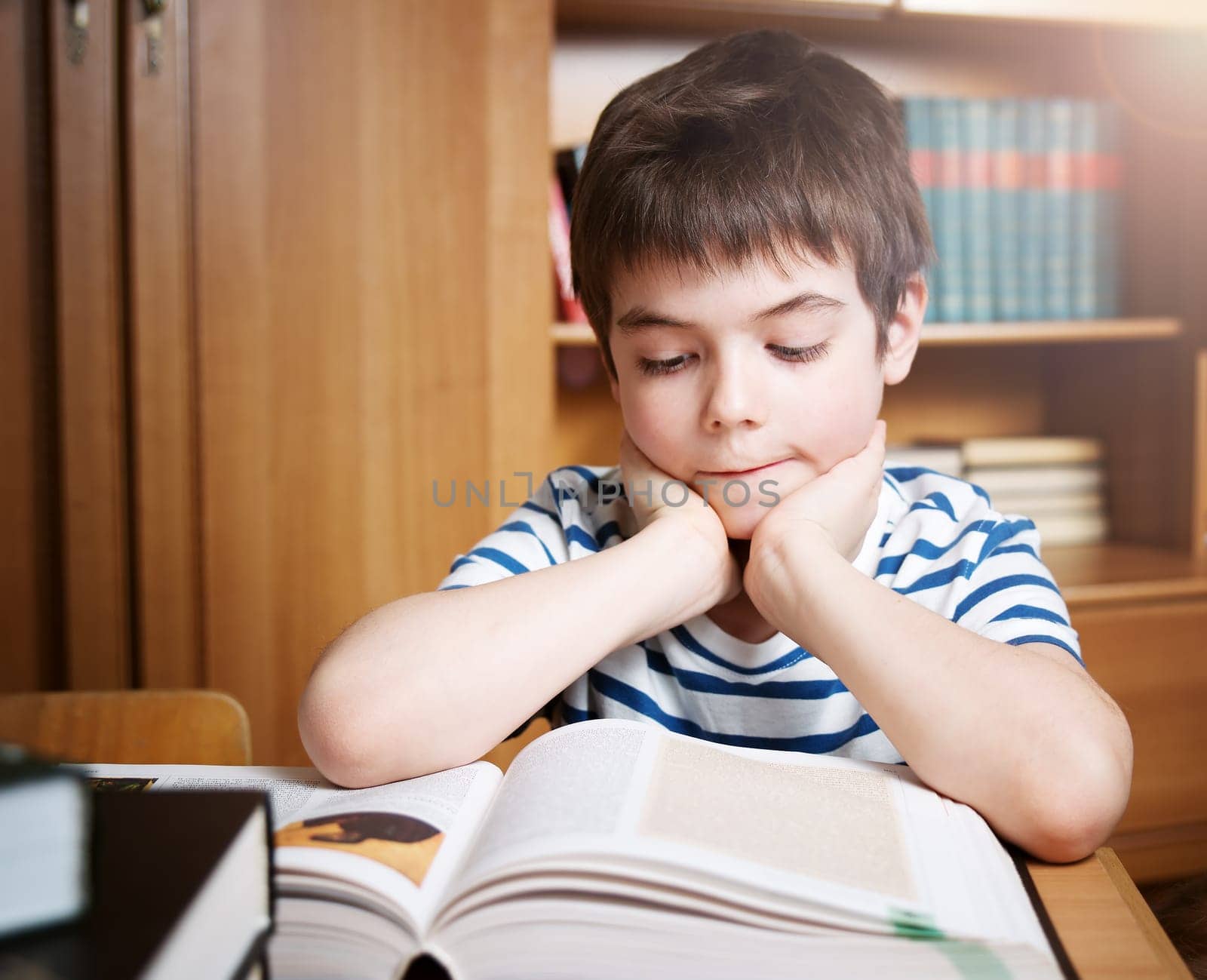seven years old child reading a book at home