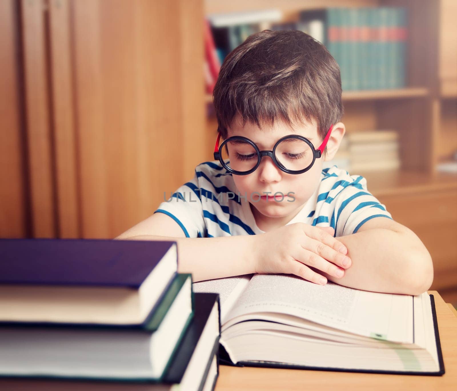 seven years old child reading a book at home