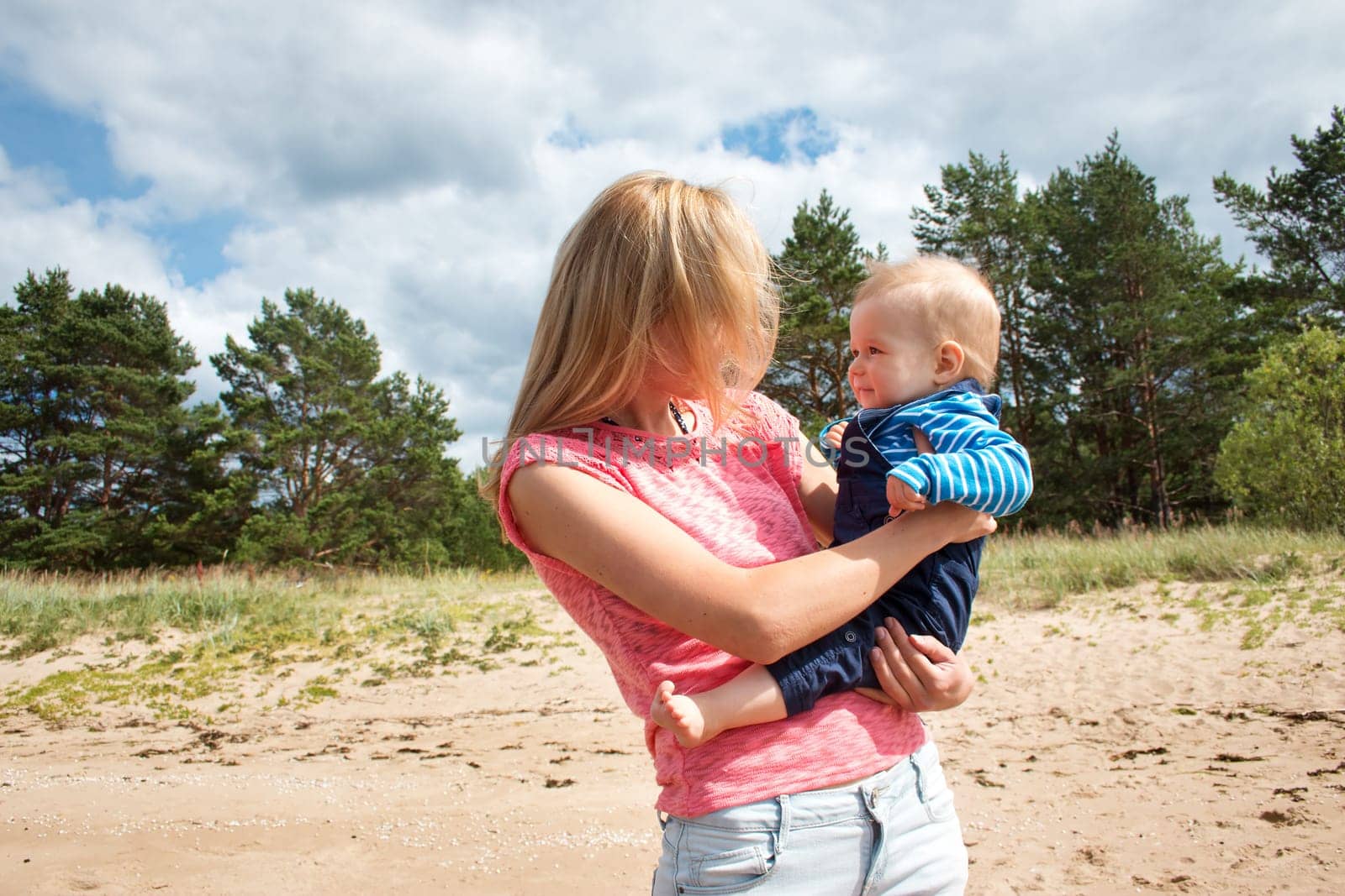young woman and baby at the beach near sea