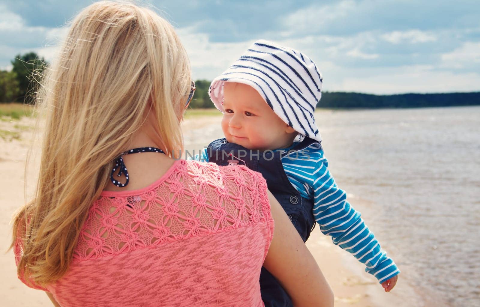 young woman and baby at the beach near sea