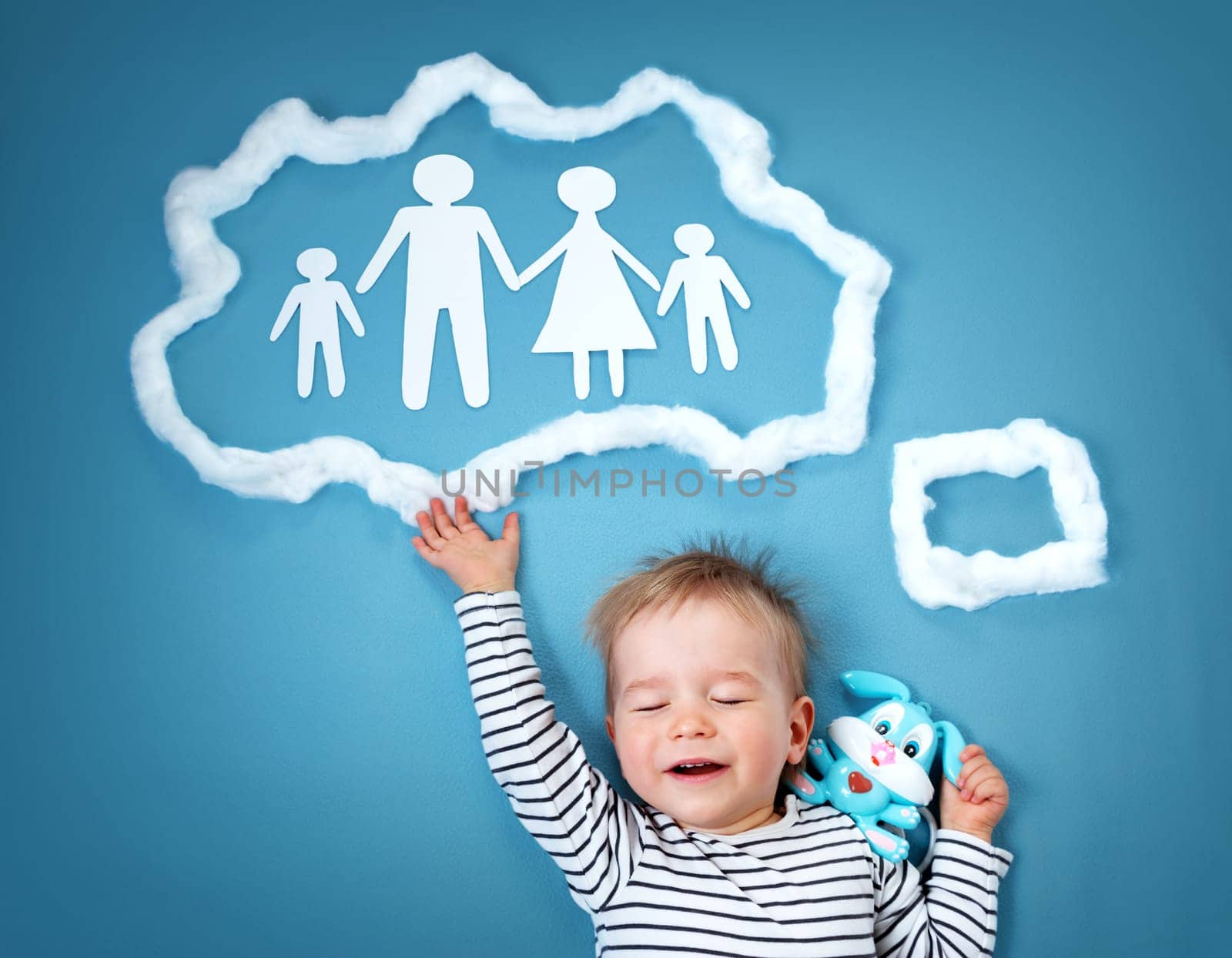 Little baby boy dreaming of a family on blue background
