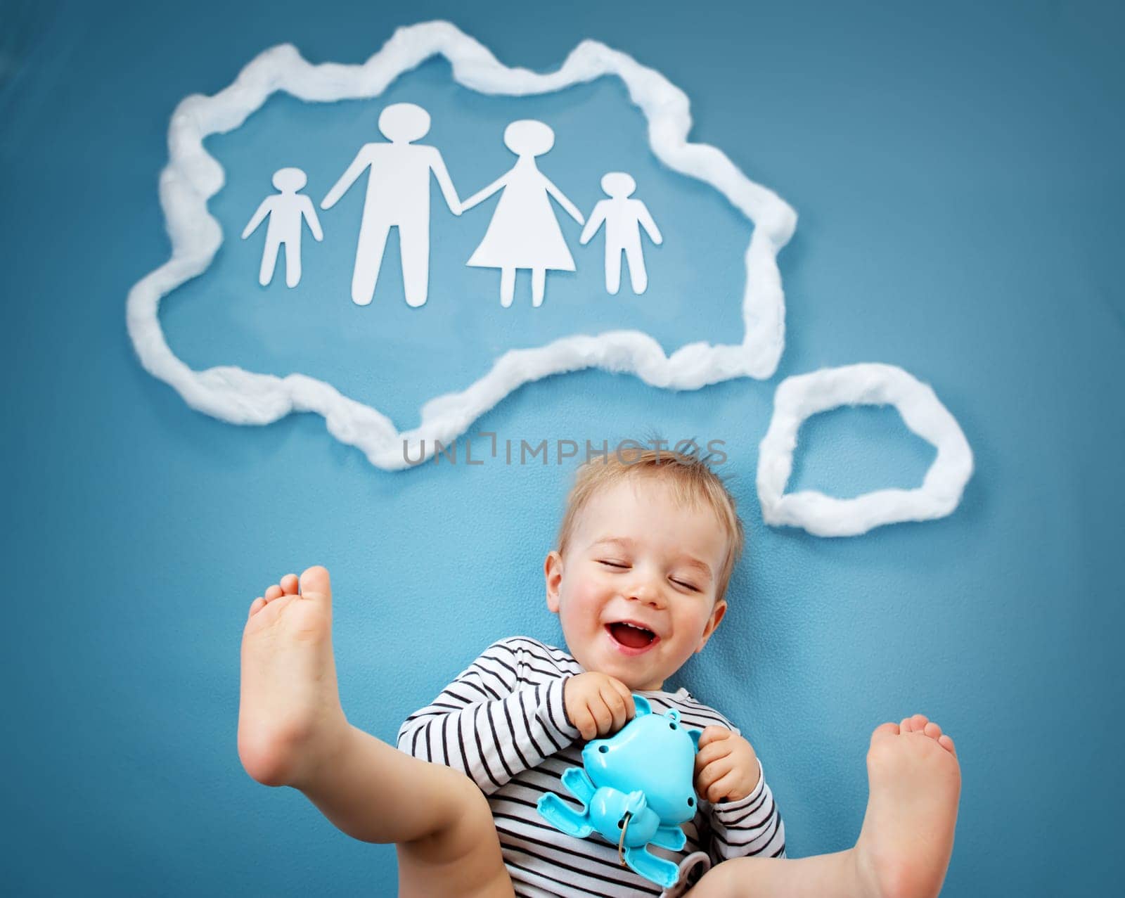 Little baby boy dreaming of a family on blue background