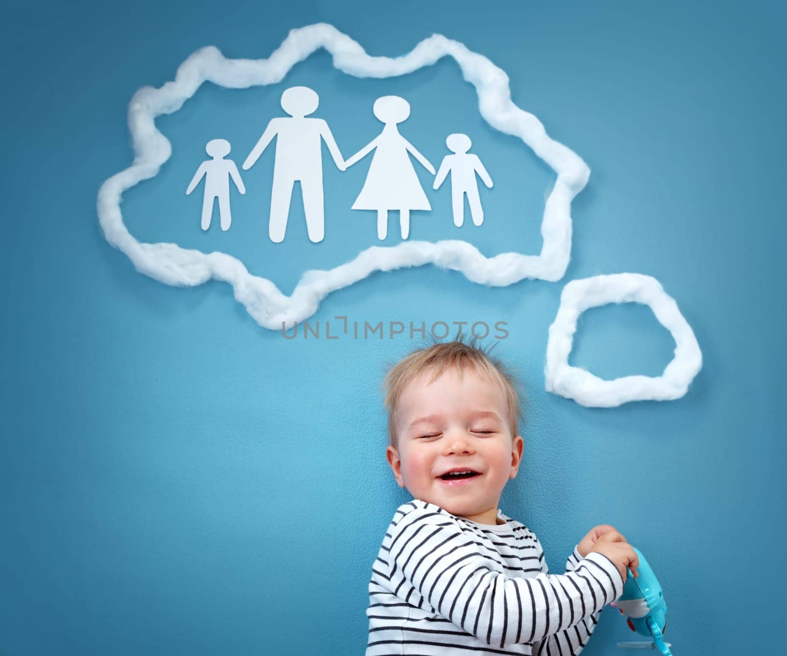 Little baby boy dreaming of a family on blue background