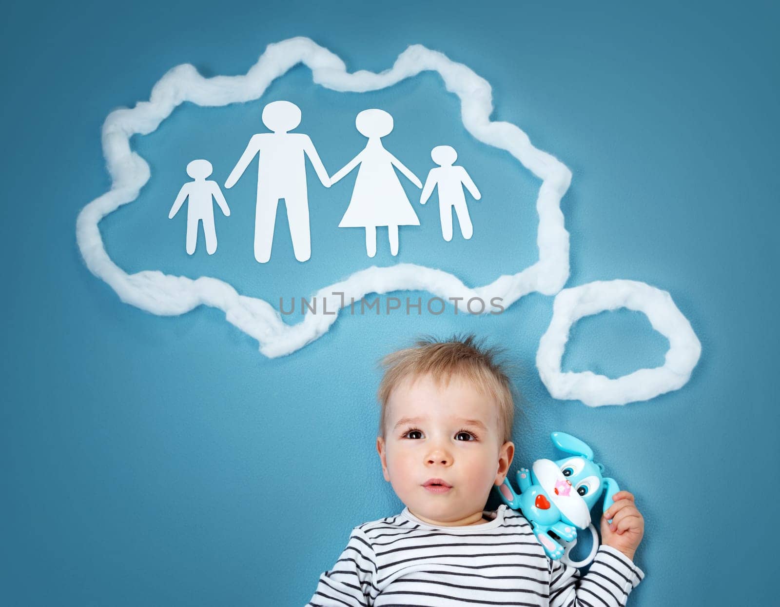 Little baby boy dreaming of a family on blue background