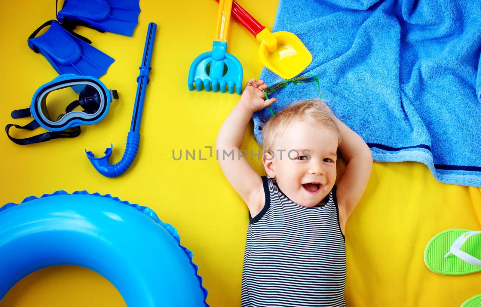 little boy with sunglasses on yellow blanket