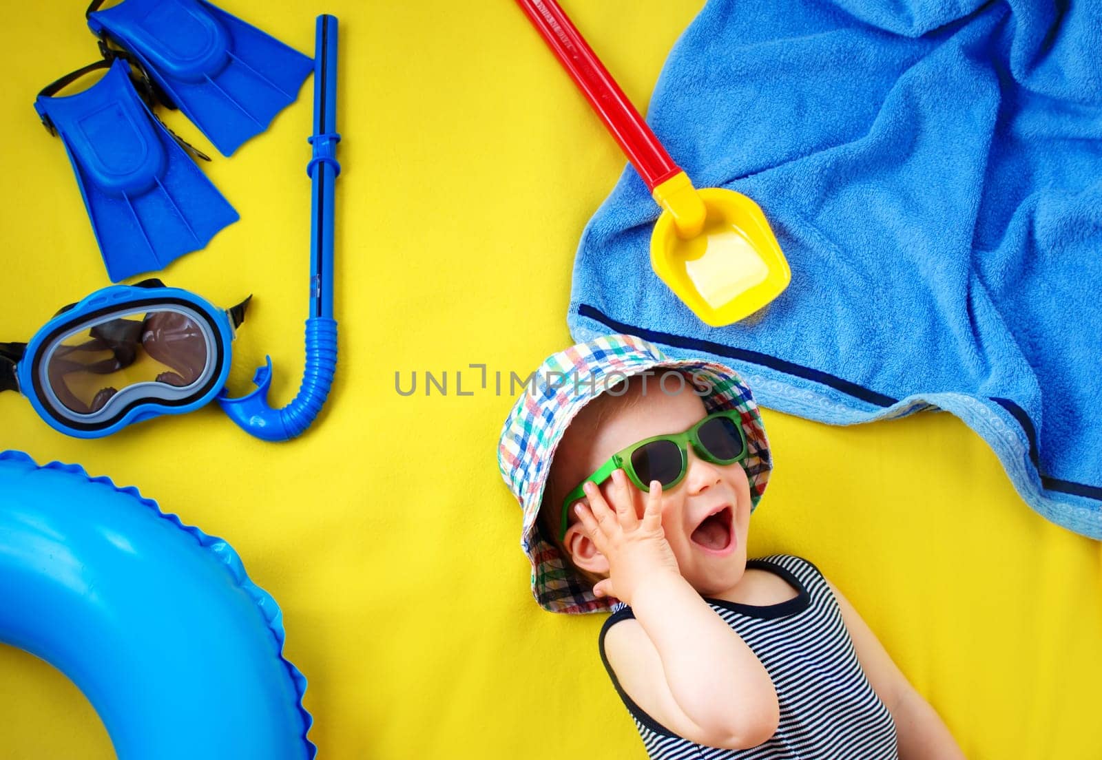 little boy with sunglasses on yellow blanket